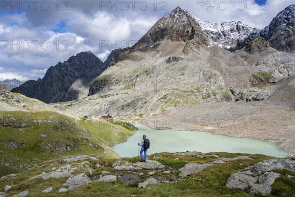 Hiker on the way to the Adolf Nossberger Hut, view of the turquoise-blue mountain lake Großer Gradensee, Schober Group, Hohe Tauern National Park, Carinthia, Austria