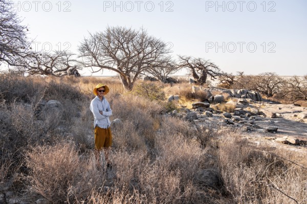 Tourist, African baobab or baobab tree (Adansonia digitata), Dry landscape, Kubu Island (Lekubu), Sowa Pan, Makgadikgadi salt pans, Botswana