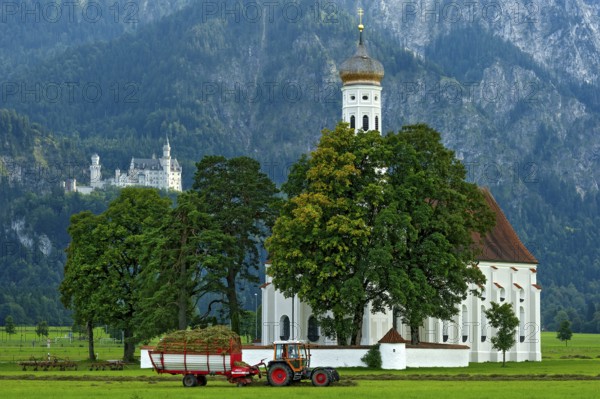 Pilgrimage church of St Coloman, Baroque, Neuschwanstein Castle by King Ludwig II, fairytale castle in the neo-Romanesque style, UNESCO World Heritage Site, tractor with hay cart in the field, Schwangau, Füssen, Allgäu, Swabia, Bavaria, Germany