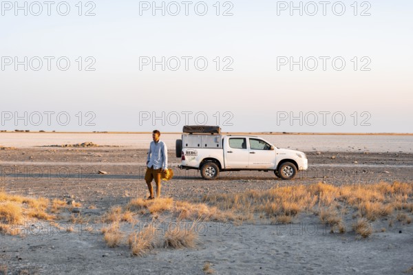 Tourist with off-road car exploring dry landscape, Kubu Island (Lekubu), Sowa Pan, Makgadikgadi salt pans, Botswana