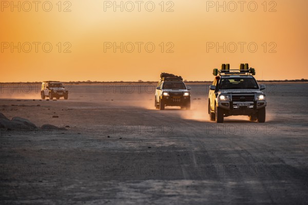 Tourists explore dry landscape by off-road car, Kubu Island (Lekubu), Sowa Pan, Makgadikgadi salt pans, Botswana