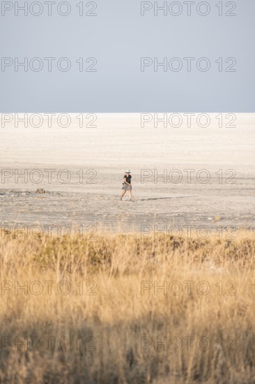 Young tourist exploring arid landscape, Kubu Island (Lekubu), Sowa Pan, Makgadikgadi salt pans, Botswana