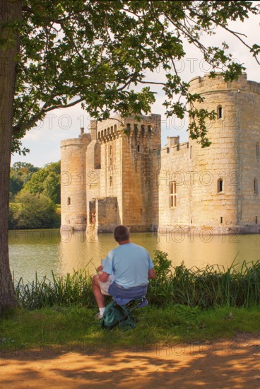 Man draws Bodiam Castle, located in East Sussex near the River Rother. It has long been one of England's most popular and best-known castles. England, UK