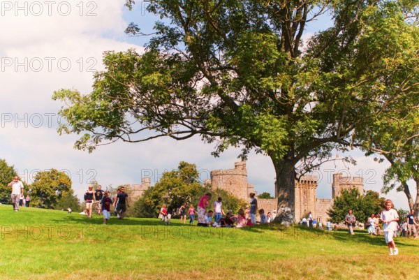 Tourists and locals in front of Bodiam Castle, located in East Sussex near the River Rother. It has long been one of England's most popular and best-known castles. England, UK