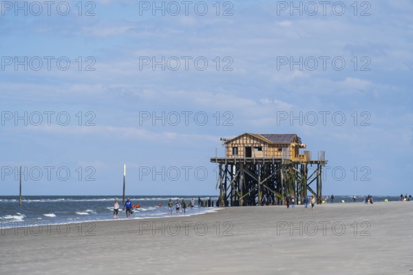 Pile dwelling and people on the beach, low tide, cloudy, Sankt Peter Ording, Eiderstedt, North Frisia, North Sea, Schleswig-Holstein, Germany