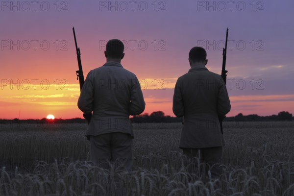 Back view of two soldiers standing in grain field watching sunset. Captures moment of reflection and calm amid nature. Generative ai, AI generated
