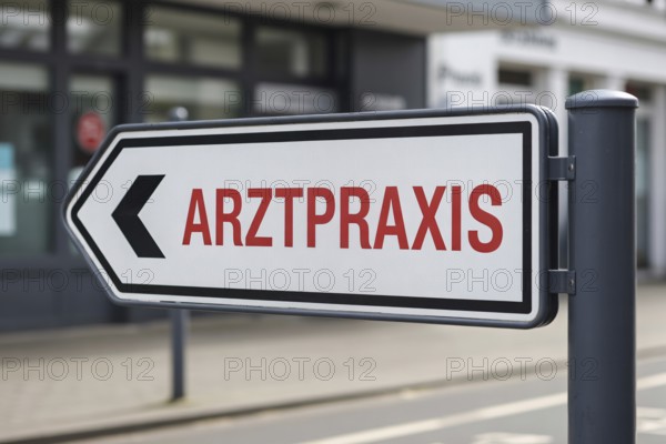 Close up of modern clean direction sign with red text Arztpraxis in sunny outdoor setting. Indicates way to medical clinic with blurred background. Generative ai, AI generated