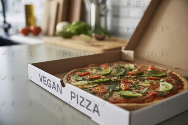 Freshly delivered vegetable pizza in box labeled vegan pizza on kitchen counter. Healthy plant-based fast food option at home. Generative ai, AI generated