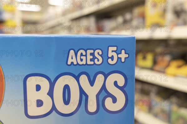 Close-up of Ages 5+ Boys text on blue toy packaging highlighting color gender coding. Generative ai, AI generated