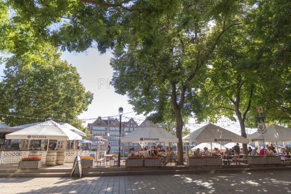 The Schlachte, historic riverside promenade along the Weser with restaurants and cafés in the shade of the trees, view of the tarred courtyard, outdoor seating area, pedestrian zone, flower pots, backlight, Old Town, Hanseatic City of Bremen, Germany