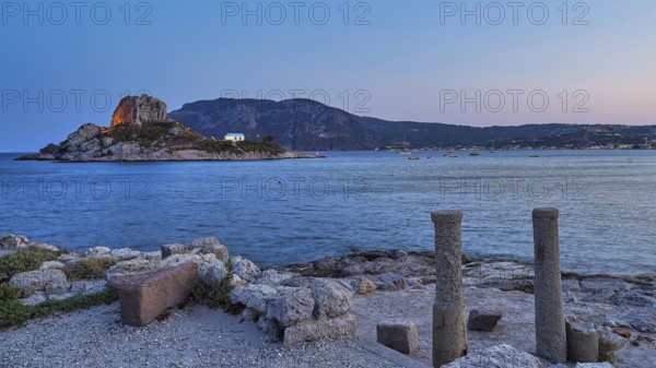 Ruins in the foreground and a calm sea with a rocky island at dusk, Agios Stefanos Beach, Agios Stefanos Basilica, Basilica, Kastri Island, Kos, Dodecanese, Greek Islands, Greece