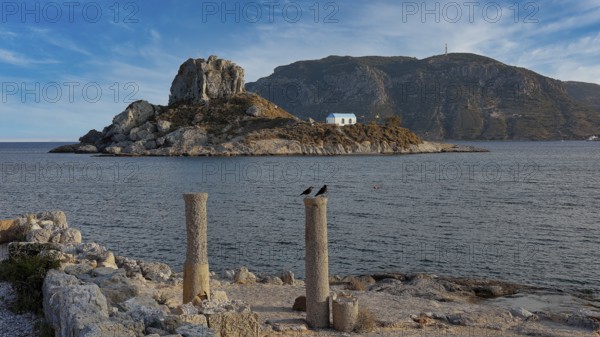 Stone columns in front of the sea with a view of an island under a slightly cloudy sky, Agios Stefanos Beach, Agios Stefanos Basilica, Basilica, Kastri Island, Kos, Dodecanese, Greek Islands, Greece