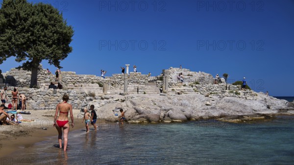 People exploring ancient ruins on the beach under a clear blue sky, Agios Stefanos Beach, Agios Stefanos Basilica, Basilica, Kastri Island, Kos, Dodecanese, Greek Islands, Greece