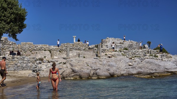 Families enjoy the day at ancient ruins by the sea with clear skies, Agios Stefanos Beach, Agios Stefanos Basilica, Basilica, Kastri Island, Kos, Dodecanese, Greek Islands, Greece