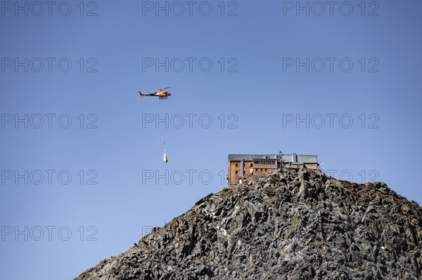 Becherhaus mountain hut on the summit of the Becher, helicopter to supply the mountain hut, Stubai Alps, South Tyrol, Italy