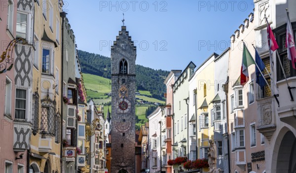 Old town, colourful houses in the main street, Zwölferturm tower at the back, old town, Sterzing, South Tyrol, Italy