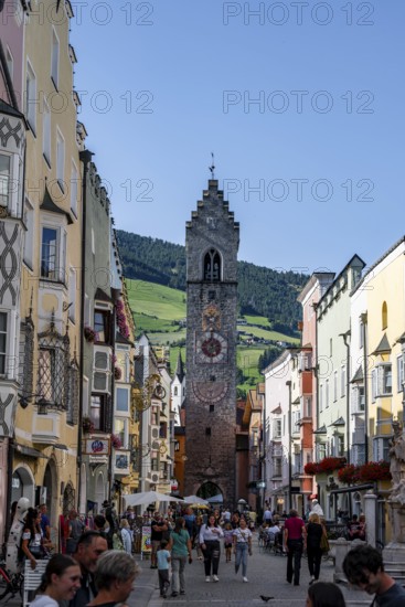 Old town, colourful houses in the main street, Zwölferturm tower at the back, old town, Sterzing, South Tyrol, Italy
