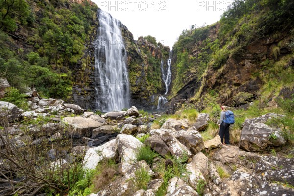 Young woman standing in front of a waterfall, Lisbon Falls, long exposure, near Graskop, Mpumalanga, South Africa