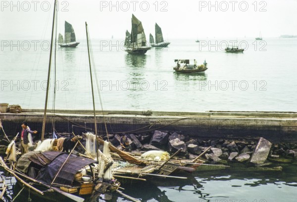 Junk ships at sea people living on sampan boats in the harbour thought to be at Causeway Bay, Hong Kong, Asia 1964