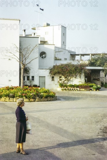 European woman standing next to Royal Hong Kong Yacht Club, Kellet Island, Causeway Bay, Hong Kong, Asia 1964