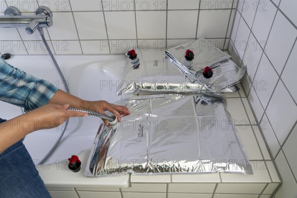 Filling a 10 litre water bag, for storing drinking water at home, as an emergency reserve in the event of a blackout or similar, lightweight, foldable, reusable bag made of multi-layer film, with dispensing device, for long-term storage of up to one year, recommended 3 litres of drinking water per person, for 10 days of storage