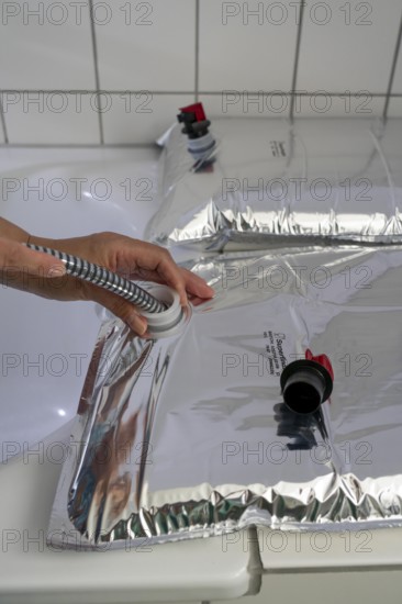 Filling a 10 litre water bag, for storing drinking water at home, as an emergency reserve in the event of a blackout or similar, lightweight, foldable, reusable bag made of multi-layer film, with dispensing device, for long-term storage of up to one year, recommended 3 litres of drinking water per person, for 10 days of storage