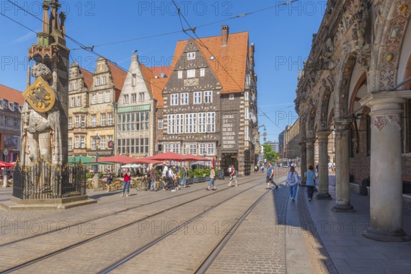 Market square with the Bremen Roland with sword and shield with imperial eagle of the Holy Roman Empire, UNESCO World Heritage Site, arcade at the Old Town Hall, historic row of houses, gabled houses, inscription, tram tracks, Old Town, Hanseatic City of Bremen, Germany