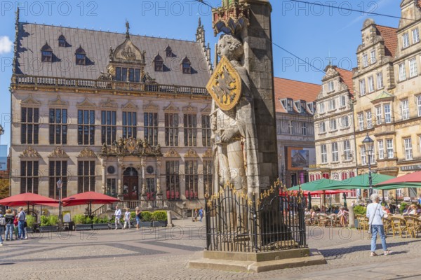 Market square with the Bremen Roland with sword and shield with imperial eagle of the Holy Roman Empire, UNESCO World Heritage Site, building of the Bremen Chamber of Commerce and the Chamber of Industry and Commerce of Bremen and Bremerhaven, historic row of houses, gabled houses, restaurant, greenery, Old Town, Hanseatic City of Bremen, Germany