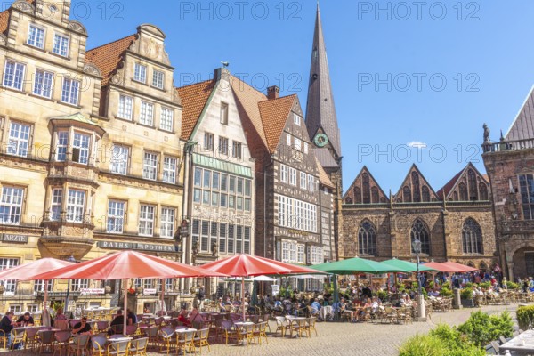 Historic row of buildings with bay windows, gabled houses, pointed tower and nave of Our Lady's Church, pointed gables, numerous tourists, market square with greenery, Old Town, Hanseatic City of Bremen, Germany