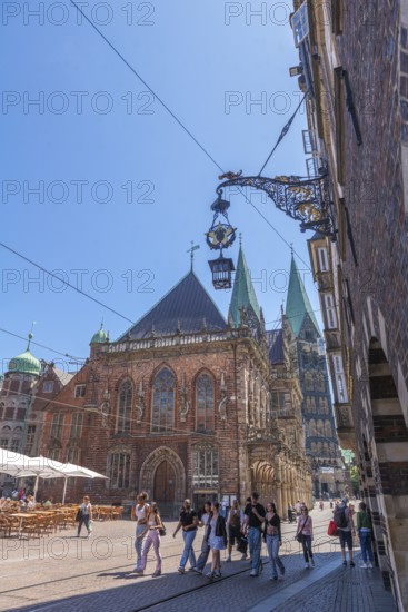 View of the old town hall, UNESCO World Heritage Site, and St Peter's Cathedral with double tower, arcade, sign, hanging lantern, blue sky, Old Town, Bremen, Germany