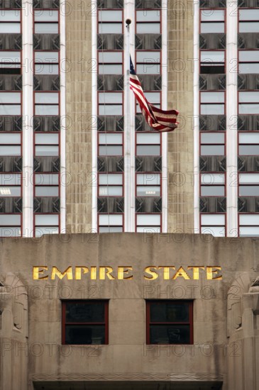 Entrance Empire State Building with US flag, New York City, USA