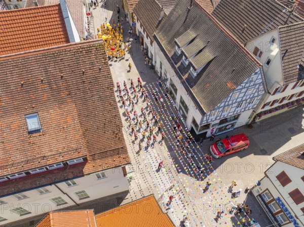 Street photographed from above during a parade. People in colourful costumes, old roofs and buildings, 950 years Calw, parade Calw, Black Forest, Germany