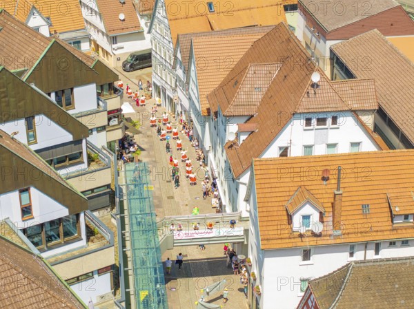 Aerial view of people moving through narrow streets of a half-timbered town under a bright sun, 950 years of Calw, Calw parade, Black Forest, Germany