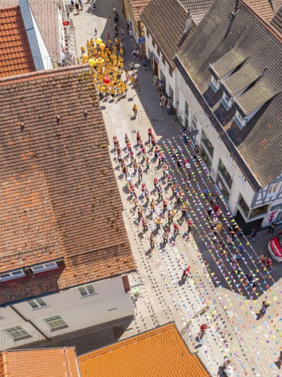 Aerial view of a street parade with people in colourful costumes between old roofs and houses, 950 years of Calw, Calw parade, Black Forest, Germany