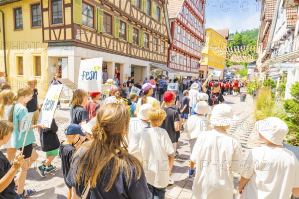 Families follow a parade in a historic town street, 950 years of Calw, Calw parade, Black Forest, Germany