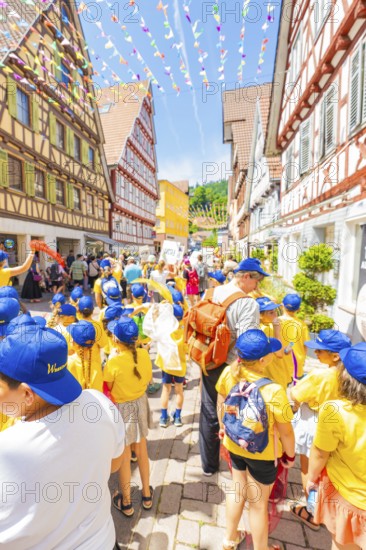 Children wear yellow clothes and blue caps at the street festival, 950 years of Calw, parade Calw, Black Forest, Germany