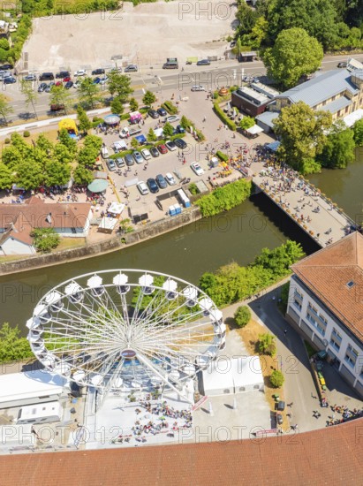 Aerial view of a Ferris wheel near a river with neighbouring town market and people in summer mood, 950 years of Calw, Calw parade, Black Forest, Germany