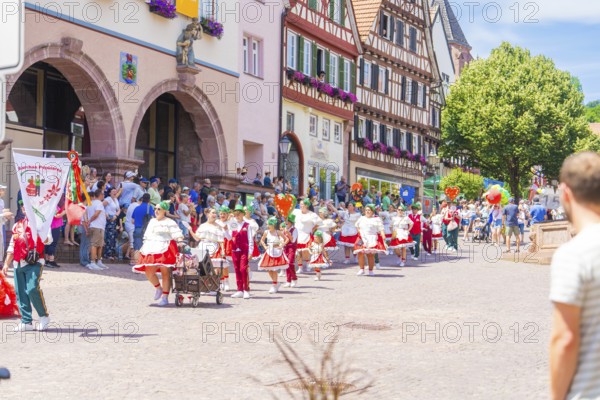 Parade with music and traditional costumes through a lively town street on a sunny day, 950 years of Calw, Calw parade, Black Forest, Germany