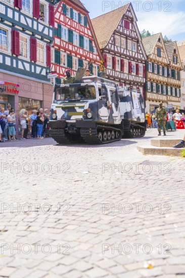 Military vehicles in a parade through a cobbled street with half-timbered houses, 950 years of Calw, Calw parade, Black Forest, Germany