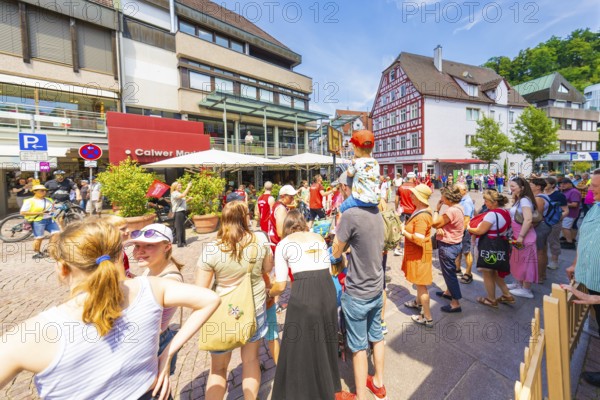 Crowds of people in the town in sunny weather, surrounded by half-timbered houses and modern architecture, 950 years of Calw, Calw parade, Black Forest, Germany
