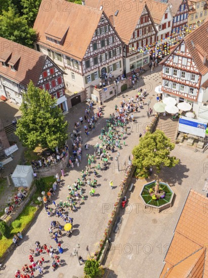 Aerial view of a village street with people in parade formation and traditional architecture, 950 years of Calw, Calw parade, Black Forest, Germany