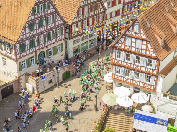 Aerial view of a group of people at a town festival, decorated with colourful balloons, 950 years of Calw, Calw parade, Black Forest, Germany
