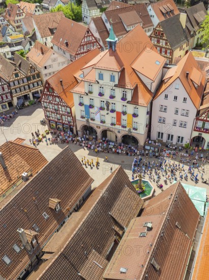 Crowd of people in front of historical buildings at a town festival, decorated with colourful flags, 950 years Calw, parade Calw, Black Forest, Germany