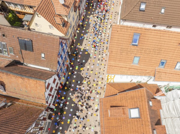 Aerial view of a busy alley with decorative colourful balloons and many people, 950 years Calw, parade Calw, Black Forest, Germany