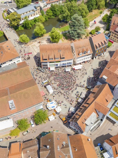 Aerial view shows a dense cityscape with people on a square, surrounded by buildings and trees, 950 years of Calw, Calw parade, Black Forest, Germany