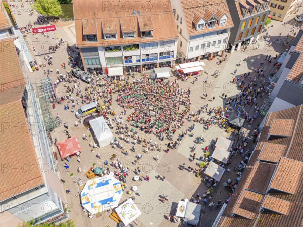 Aerial view of a busy market square with a crowd of people and surrounding buildings in a summer atmosphere, 950 years of Calw, Calw parade, Black Forest, Germany