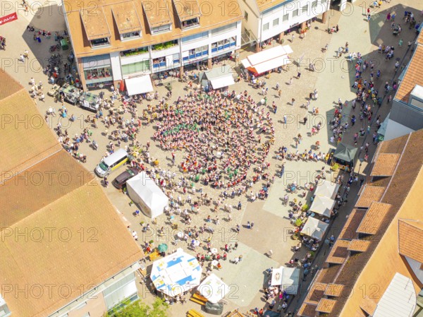 Vivid aerial view of a square where a crowd is taking part in a public celebration, 950 years of Calw, Calw parade, Black Forest, Germany