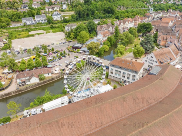 Town view with Ferris wheel and river, surrounded by buildings and green landscapes, 950 years of Calw, Calw parade, Black Forest, Germany