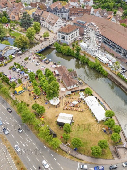 Park event near the city centre with people and Ferris wheel on a river, surrounded by streets, 950 years of Calw, Calw parade, Black Forest, Germany