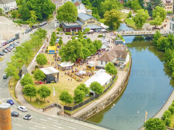 Aerial view of a small park with people, surrounded by a river and city infrastructure, 950 years of Calw, Calw parade, Black Forest, Germany